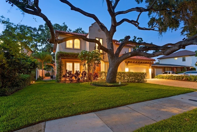 3307 W Knights Ave, Tampa, FL 33611 - mediterranean / spanish-style house with a tiled roof, driveway, a front lawn, stucco siding, and a garage