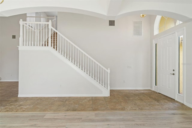 3013 Silvermill Loop Unit O, Land O Lakes, FL 34638 - foyer entrance featuring stairway, a high ceiling, stone finish flooring, and arched walkways