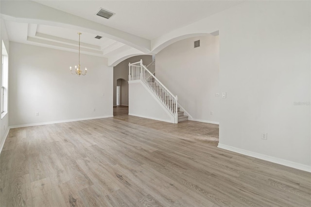 3013 Silvermill Loop Unit O, Land O Lakes, FL 34638 - unfurnished living room featuring arched walkways, a chandelier, stairway, and light wood finished floors