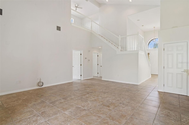 3013 Silvermill Loop Unit O, Land O Lakes, FL 34638 - unfurnished living room with a towering ceiling, ceiling fan, stairs, and stone finish floors