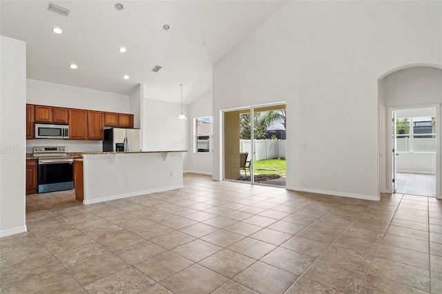 3013 Silvermill Loop Unit O, Land O Lakes, FL 34638 - kitchen featuring stainless steel appliances, open floor plan, high vaulted ceiling, arched walkways, and a kitchen bar