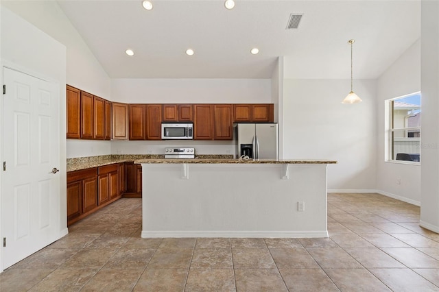 3013 Silvermill Loop Unit O, Land O Lakes, FL 34638 - kitchen featuring stainless steel appliances, vaulted ceiling, stone counters, a center island with sink, and brown cabinetry