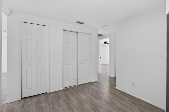 4535 15th Ave S, Saint Petersburg, FL 33711 - unfurnished bedroom with wood finished floors and multiple closets