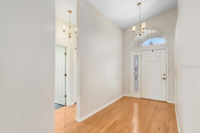 4407 Whitton Way, New Port Richey, FL 34653 - foyer entrance featuring a chandelier, light wood finished floors, and high vaulted ceiling