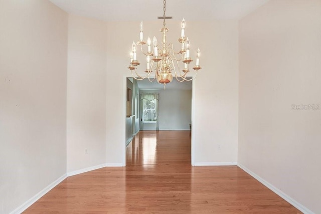 4407 Whitton Way, New Port Richey, FL 34653 - unfurnished dining area featuring a chandelier and wood finished floors