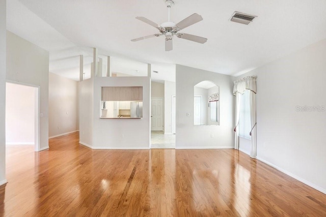 4407 Whitton Way, New Port Richey, FL 34653 - unfurnished living room featuring vaulted ceiling, a ceiling fan, wood finished floors, and arched walkways
