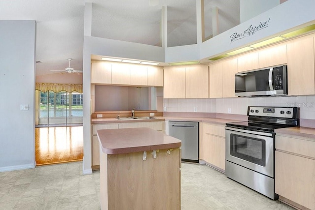 4407 Whitton Way, New Port Richey, FL 34653 - kitchen with appliances with stainless steel finishes, tasteful backsplash, a center island, light brown cabinets, and light countertops