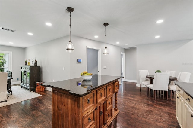 126 Holly Tree Ln, Brandon, FL 33511 - kitchen featuring dark wood-style flooring, recessed lighting, a center island, hanging light fixtures, and dark stone counters