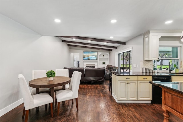 126 Holly Tree Ln, Brandon, FL 33511 - kitchen featuring black dishwasher, a fireplace, dark wood-style flooring, cream cabinets, and recessed lighting
