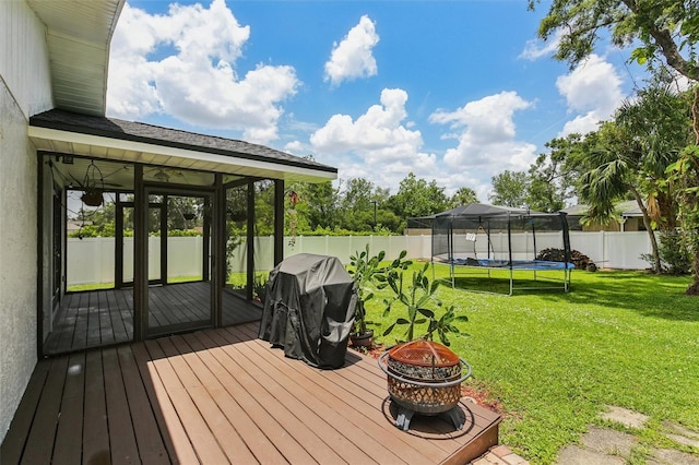 126 Holly Tree Ln, Brandon, FL 33511 - wooden terrace featuring an outdoor fire pit, a trampoline, a fenced backyard, a sunroom, and a grill