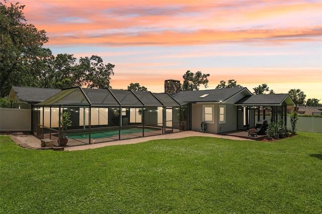 126 Holly Tree Ln, Brandon, FL 33511 - back of house at dusk featuring a patio, an outdoor pool, a fenced backyard, a chimney, and a shingled roof