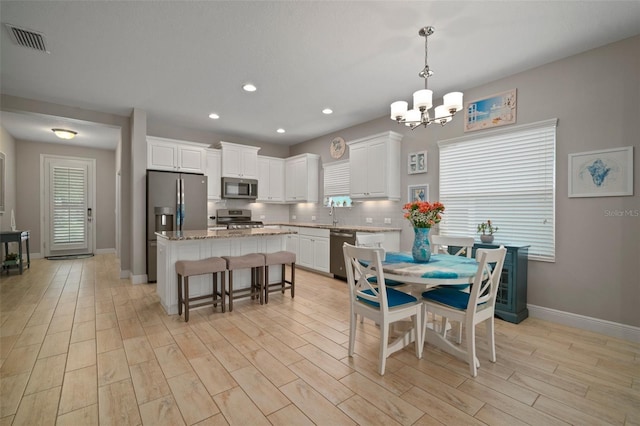 6408 Seasound Dr, Apollo Beach, FL 33572 - dining area with a chandelier, light wood-style flooring, and recessed lighting