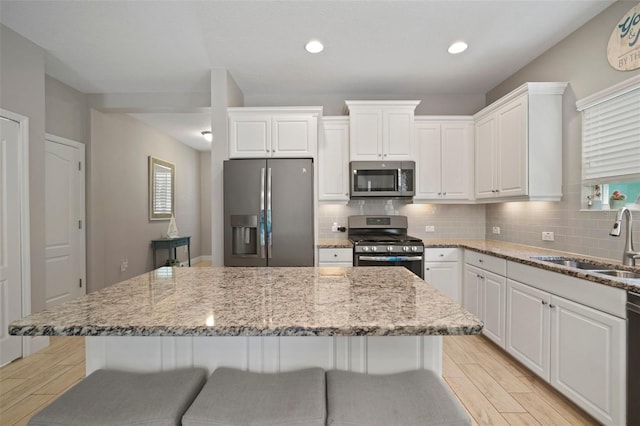6408 Seasound Dr, Apollo Beach, FL 33572 - kitchen featuring stainless steel appliances, light wood-type flooring, a center island, decorative backsplash, and recessed lighting