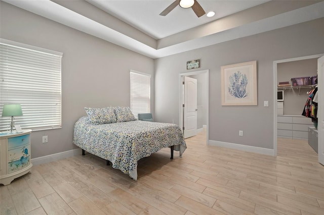 6408 Seasound Dr, Apollo Beach, FL 33572 - bedroom with a walk in closet, light wood-type flooring, multiple windows, and a closet