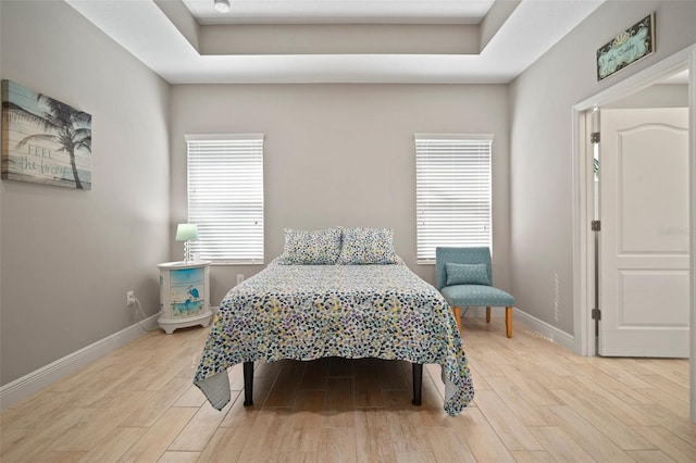 6408 Seasound Dr, Apollo Beach, FL 33572 - bedroom featuring light wood-style flooring and a tray ceiling