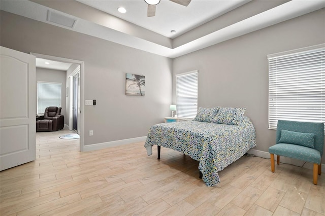 6408 Seasound Dr, Apollo Beach, FL 33572 - bedroom featuring light wood-type flooring, a ceiling fan, a tray ceiling, and recessed lighting