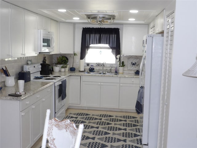 1250 S Pinellas Ave Unit 1013, Tarpon Springs, FL 34689 - kitchen with white appliances, white cabinetry, tasteful backsplash, light tile patterned floors, and light stone counters