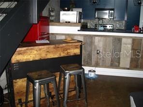 2001 E 2nd Ave Unit 27, Tampa, FL 33605 - bar with stainless steel microwave, decorative backsplash, and fridge