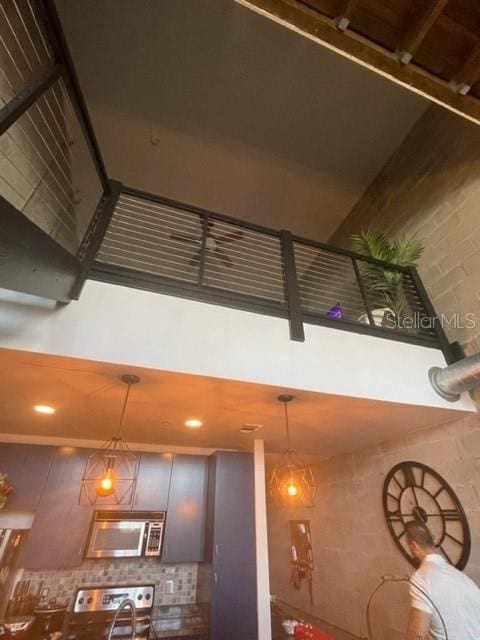 2001 E 2nd Ave Unit 27, Tampa, FL 33605 - kitchen view of stainless steel microwave, pendant lighting, stove, decorative backsplash, and recessed lighting