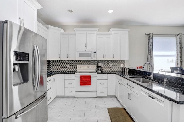 30247 Emmetts Ct, Wesley Chapel, FL 33543 - kitchen featuring white appliances, light marble finish floors, white cabinets, dark stone countertops, and recessed lighting