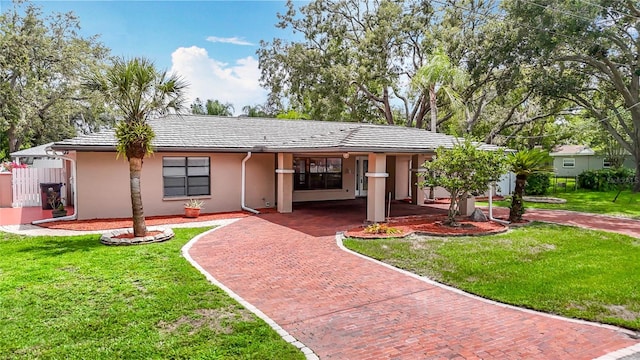 4002 Hudson Ter, Tampa, FL 33618 - ranch-style house with stucco siding, a front lawn, decorative driveway, and a carport