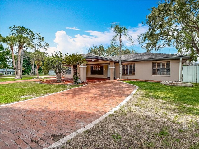 4002 Hudson Ter, Tampa, FL 33618 - ranch-style house featuring stucco siding, a front lawn, and decorative driveway
