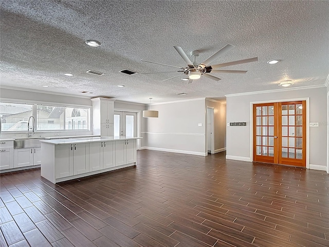 4002 Hudson Ter, Tampa, FL 33618 - unfurnished living room with crown molding, wood finish floors, a ceiling fan, french doors, and a textured ceiling
