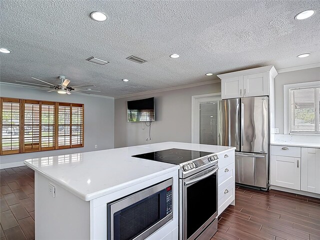 4002 Hudson Ter, Tampa, FL 33618 - kitchen featuring appliances with stainless steel finishes, ornamental molding, a ceiling fan, light countertops, and wood finish floors