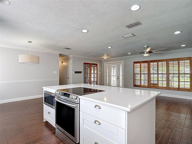 4002 Hudson Ter, Tampa, FL 33618 - kitchen with stainless steel appliances, dark wood finished floors, a textured ceiling, white cabinetry, and light countertops