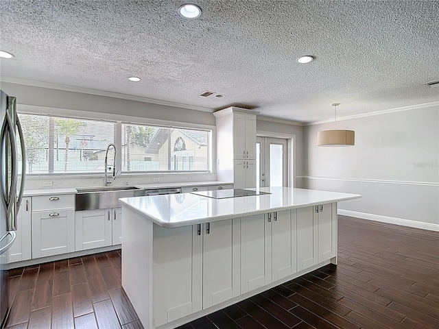 4002 Hudson Ter, Tampa, FL 33618 - kitchen with a center island, dark wood-type flooring, stainless steel fridge, light countertops, and ornamental molding