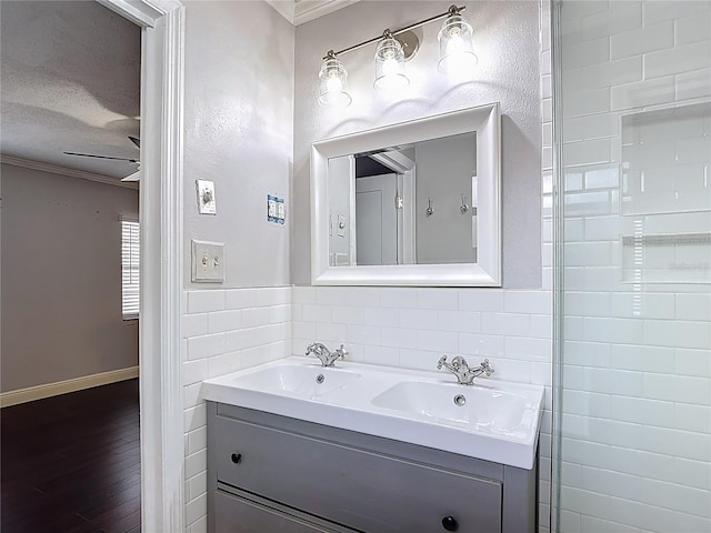 4002 Hudson Ter, Tampa, FL 33618 - bathroom featuring crown molding, double vanity, wood finished floors, and a textured ceiling