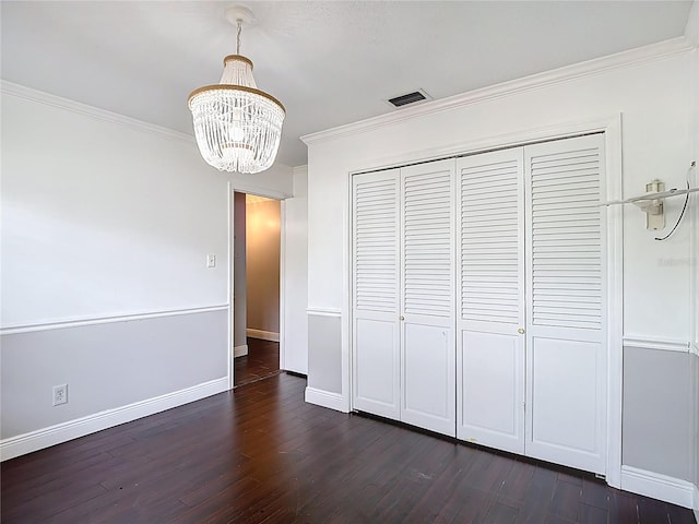 4002 Hudson Ter, Tampa, FL 33618 - unfurnished dining area with a chandelier, ornamental molding, and dark wood-style flooring