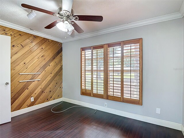 4002 Hudson Ter, Tampa, FL 33618 - spare room with wooden walls, ornamental molding, a ceiling fan, an accent wall, and wood finished floors