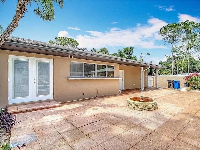 4002 Hudson Ter, Tampa, FL 33618 - rear view of property with a patio, french doors, stucco siding, and an outdoor fire pit