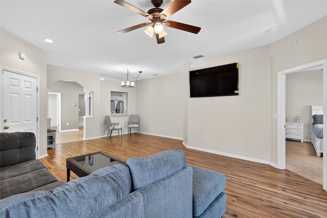 1822 Sassafras Dr, Wesley Chapel, FL 33543 - living room with arched walkways, wood finished floors, ceiling fan, recessed lighting, and a chandelier