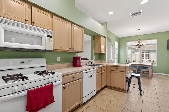 1822 Sassafras Dr, Wesley Chapel, FL 33543 - kitchen featuring white appliances, light countertops, light brown cabinets, a chandelier, and a peninsula