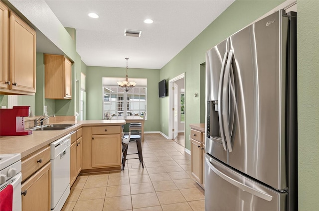 1822 Sassafras Dr, Wesley Chapel, FL 33543 - kitchen with white appliances, a peninsula, light countertops, light brown cabinetry, and a chandelier