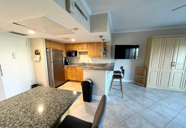 880 Mandalay Ave Unit C412, Clearwater Beach, FL 33767 - kitchen with freestanding refrigerator, black microwave, light tile patterned flooring, ornamental molding, and a kitchen bar