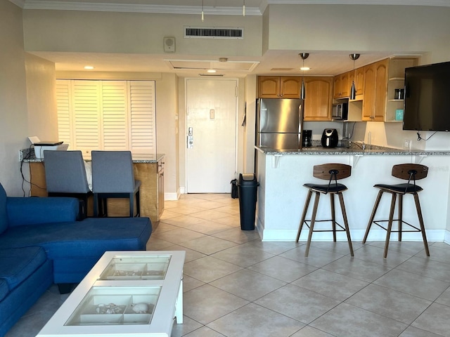 880 Mandalay Ave Unit C412, Clearwater Beach, FL 33767 - kitchen featuring freestanding refrigerator, black microwave, ornamental molding, light tile patterned floors, and a peninsula