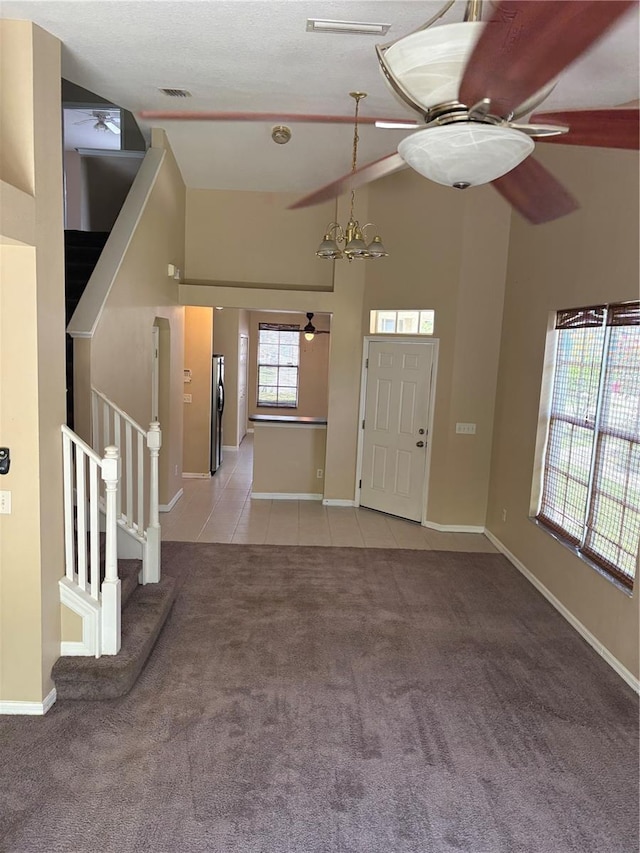 6252 Olivedale Dr, Riverview, FL 33578 - foyer entrance with a ceiling fan, light carpet, stairs, high vaulted ceiling, and light tile patterned floors