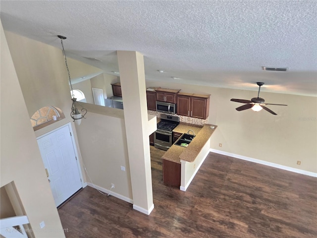 31141 Harthorn Ct, Wesley Chapel, FL 33543 - kitchen with appliances with stainless steel finishes, a textured ceiling, dark wood-style floors, a ceiling fan, and a peninsula