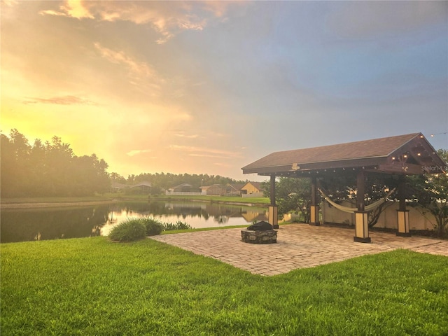31141 Harthorn Ct, Wesley Chapel, FL 33543 - view of grassy yard featuring an outdoor fire pit, a water view, and a patio