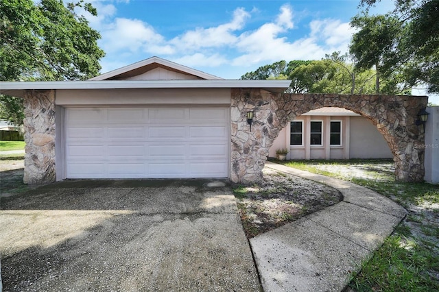 2817 Rustic Oaks Dr, Palm Harbor, FL 34684 - view of front of property featuring stone siding, asphalt driveway, and an attached garage