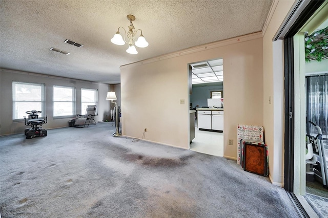 2817 Rustic Oaks Dr, Palm Harbor, FL 34684 - unfurnished living room featuring a chandelier, a textured ceiling, and carpet floors