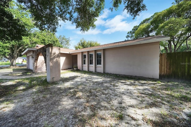 2817 Rustic Oaks Dr, Palm Harbor, FL 34684 - back of house with stucco siding and a garage