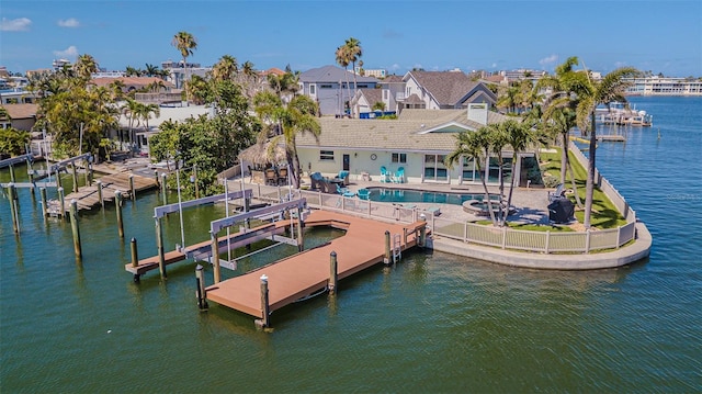 5950 Bikini Way N, St Pete Beach, FL 33706 - dock featuring boat lift, an outdoor pool, a patio area, a water view, and a fenced backyard