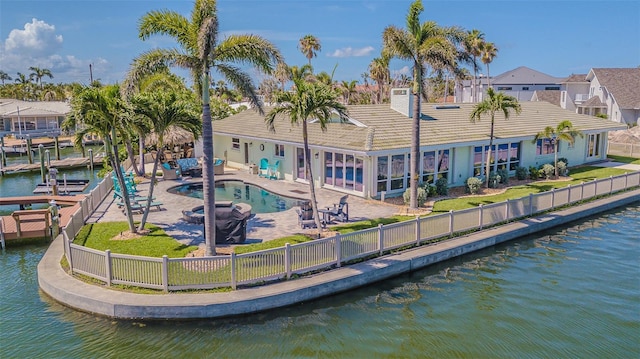 5950 Bikini Way N, St Pete Beach, FL 33706 - back of property featuring a fenced backyard, a patio area, a water view, and a tiled roof