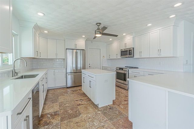 5950 Bikini Way N, St Pete Beach, FL 33706 - kitchen with stainless steel appliances, backsplash, white cabinetry, and recessed lighting