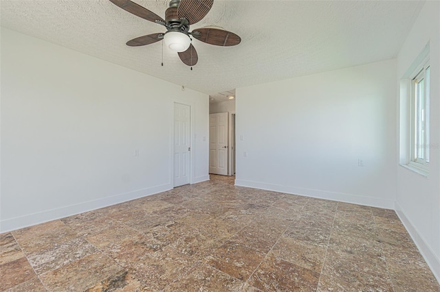 5950 Bikini Way N, St Pete Beach, FL 33706 - empty room featuring a ceiling fan, a textured ceiling, and stone finish flooring