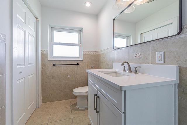 5950 Bikini Way N, St Pete Beach, FL 33706 - bathroom with tile walls, vanity, tile patterned flooring, and wainscoting